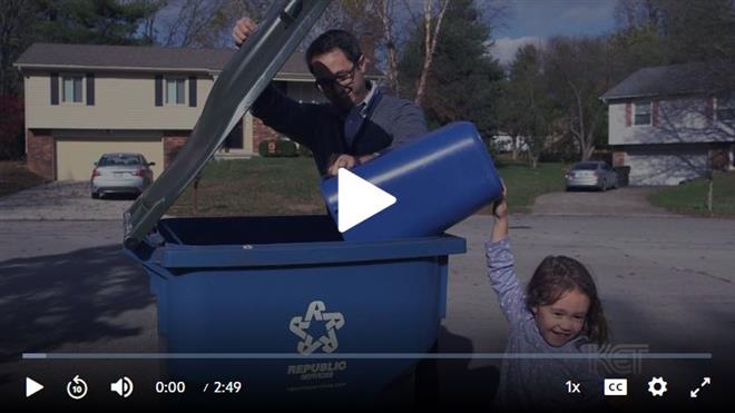 screenshot of video - father and daughter emptying recycles into can