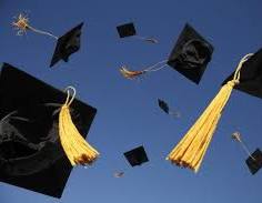  Graduation caps with yellow tassels being tossed into a clear blue sky.