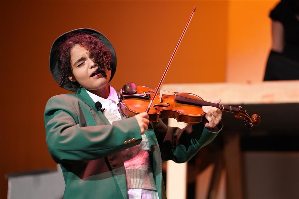 Student playing instrument on stage