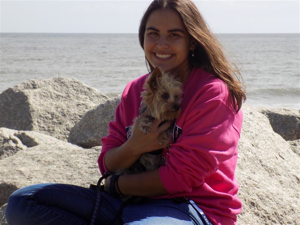 Ms. Mishra and her dog on a rock outside